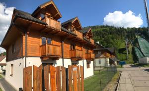 シュチルクにあるSno Apartmentsの木製バルコニーと柵付きの建物