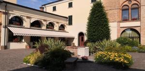 un edificio con un albero e fiori in un cortile di Villa Santa Maria dell'Arco - Centro Oreb a Cazzago San Martino