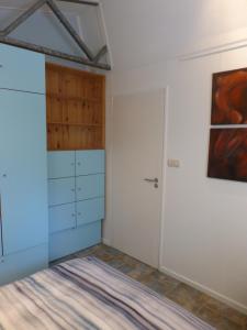 a bedroom with a closet and a door at Vakantiehuis Onder de Peppel met sauna en jacuzzi in Wijk en Aalburg