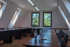 uma fila de mesas numa sala com janelas em Hotel Marami em Sinaia