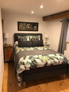 1 dormitorio con 1 cama con colcha verde en Les Gîtes du Racème, en Blienschwiller