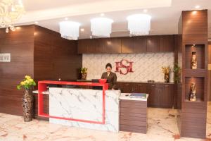 a man standing at a desk in a lobby at Stayotel Kolkata Airport in Kolkata