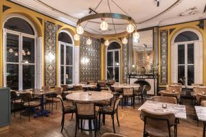 a restaurant with tables and chairs and a chandelier at Vaeshartelt Maastricht - Free Parking in Maastricht