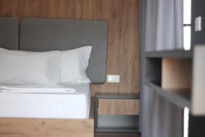 a bed with white sheets and pillows in a room at Le Rêve Boutique Hotel in Dhërmi