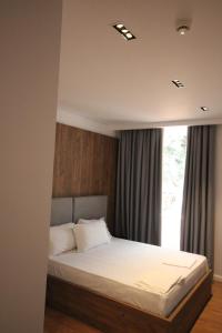 a bedroom with a bed with a large window at Le Rêve Boutique Hotel in Dhërmi