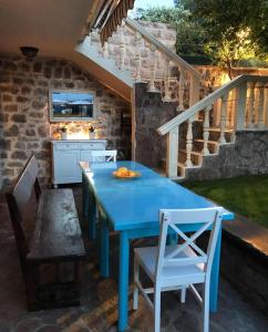 Villa Stella Rose في لوستيكا: طاولة زرقاء وكراسي على فناء مع درج