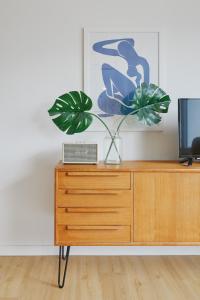 a vase with a plant on top of a dresser at Welcome in - Ferienwohnung 'Tremonia', gegenüber der Piste mit Balkon in Winterberg