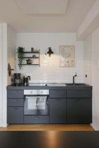 a kitchen with a stove and a sink at Welcome in - Ferienwohnung 'Tremonia', gegenüber der Piste mit Balkon in Winterberg