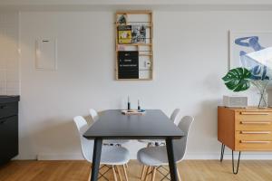 a dining room with a black table and white chairs at Welcome in - Ferienwohnung 'Tremonia', gegenüber der Piste mit Balkon in Winterberg