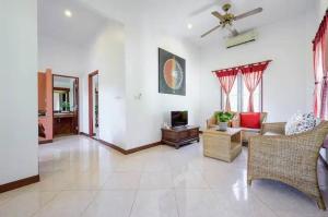 a living room with a couch and a tv at Palm Village in Rawai Beach