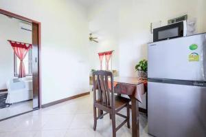 a kitchen with a table and a refrigerator and a chair at Palm Village in Rawai Beach