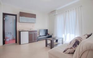 a white living room with a couch and a table at Mandir apartments - Center in Budva