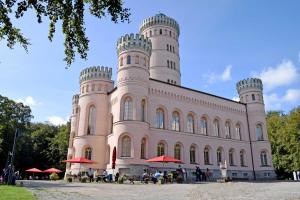a large castle with people sitting outside of it at Ferienwohnung Marie an der Granitz in Schmacht