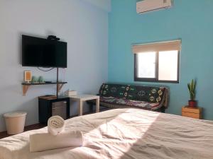a bedroom with a bed and a tv and a couch at Say Hi B&B in Manzhou