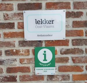 a sign on a brick wall that reads keller guest rooms at B&B La Clé du Sud in Merelbeke