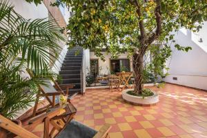 a courtyard with a tree and chairs and stairs at Lemon Tree Stay in Faro