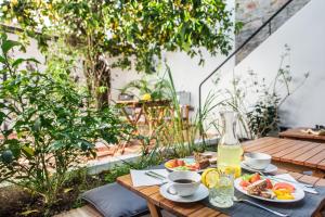 a wooden table with food and drinks on it at Lemon Tree Stay in Faro