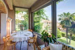 una sala da pranzo con tavolo e una grande finestra di "Luisa's Smile" a Guarene