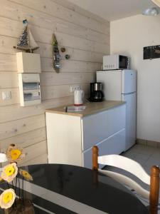 a kitchen with a table and a white refrigerator at Maison Bord de Mer LE BIGORNEAU l'Herbaudière in Noirmoutier-en-l'lle +18 photos