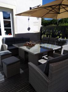 une terrasse avec une table, des chaises et un parasol dans l'établissement Chambres d'Hôtes le Clos des Lesses, à Fresse-sur-Moselle