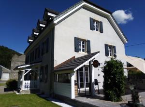 een wit huis met zwarte ramen en een garage bij Chambres d'Hôtes le Clos des Lesses in Fresse-sur-Moselle