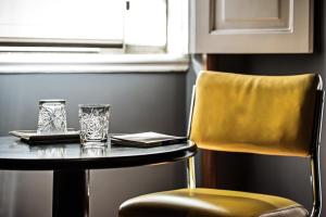 a table with two glasses and a yellow chair at Lemon Tree Stay in Faro