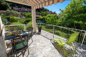 eine Terrasse mit einem Tisch und Stühlen auf dem Balkon in der Unterkunft Apartments Rosovic J&C in Mošćenička Draga