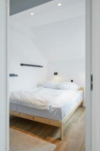 a bedroom with a bed with white sheets at Welcome in - Modernes Apartment 70-MA in der Nähe der Skipiste in Winterberg