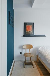 a bedroom with a chair next to a bed at Welcome in - Modernes Apartment 70-MA in der Nähe der Skipiste in Winterberg