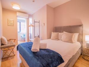 - une chambre avec un grand lit et une couverture bleue dans l'établissement ALIBI by YoursPorto, à Porto