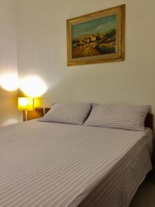 オルビアにあるShort Letの白いベッド1台付きのベッドルーム1室(壁に絵画付)