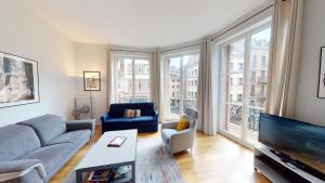uma sala de estar com um sofá e uma televisão em Bleu Mésange - 2 Bedrooms and 2 Bathrooms em Estrasburgo