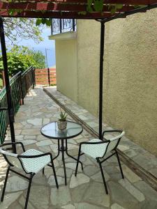 a patio with a table and two chairs and an umbrella at Elenis Vista Mare in Kalamaki