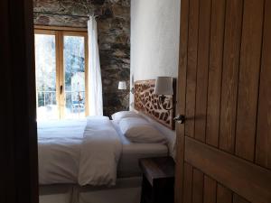 1 dormitorio con cama y ventana en Casa de La Roca - Only Adults., en Vilallonga de Ter