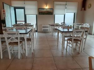 Locanda Orvieto Agriturismo في أورفييتو: غرفة طعام مع طاولات وكراسي ونوافذ