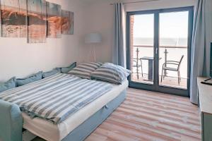 een slaapkamer met een bed en een balkon bij Boddenkieker in Barth