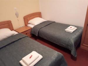 two beds in a room with towels on them at Hotel Rakov Skocjan in Cerknica