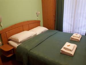 a bedroom with a bed with two towels on it at Hotel Rakov Skocjan in Cerknica