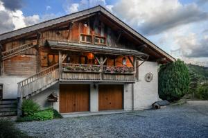 a wooden house with a balcony and two doors at Chalet du Renard in Flumet