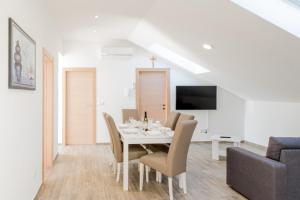 Apartments Žilić في Kaštel Stari: غرفة طعام بيضاء مع طاولة بيضاء وكراسي