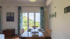 une salle à manger avec une table et une grande fenêtre dans l'établissement Italianway - Fontanelle 34, à Alassio