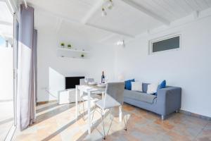 a white living room with a blue couch and a table at Casa Amanecer 2 in Mácher