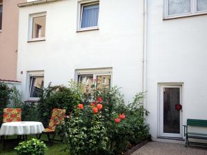 a table and chairs in front of a white house at Ferienwohnung S und K Bremerhaven in Bremerhaven