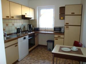 a small kitchen with a sink and a table at Ferienwohnung S und K Bremerhaven in Bremerhaven +3 photos