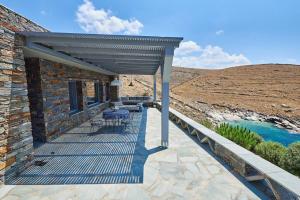 a patio with a table and chairs on a building at Villa Indaco in Koundouros