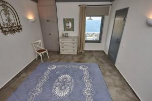Villa Indaco في Koundouros: غرفة معيشة مع سجادة زرقاء على الأرض
