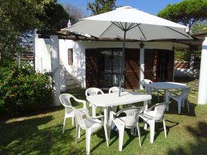 una mesa, sillas y una sombrilla en el patio en Vilamoura Fantástica Moradia com Piscina Privada, en Vilamoura