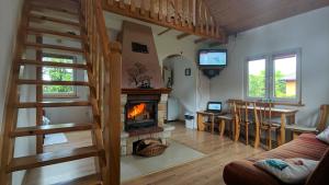 a living room with a fireplace and a dining room at Domek pod Czulnią in Uherce Mineralne (7)