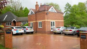 a group of cars parked in front of a brick house at Ironbridge Home with Roof Terrace in Ironbridge