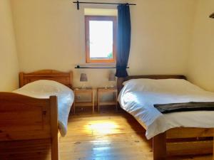 - une chambre avec 2 lits et une fenêtre dans l'établissement Gites La Chabanaise, à Beaulieu-sur-Dordogne